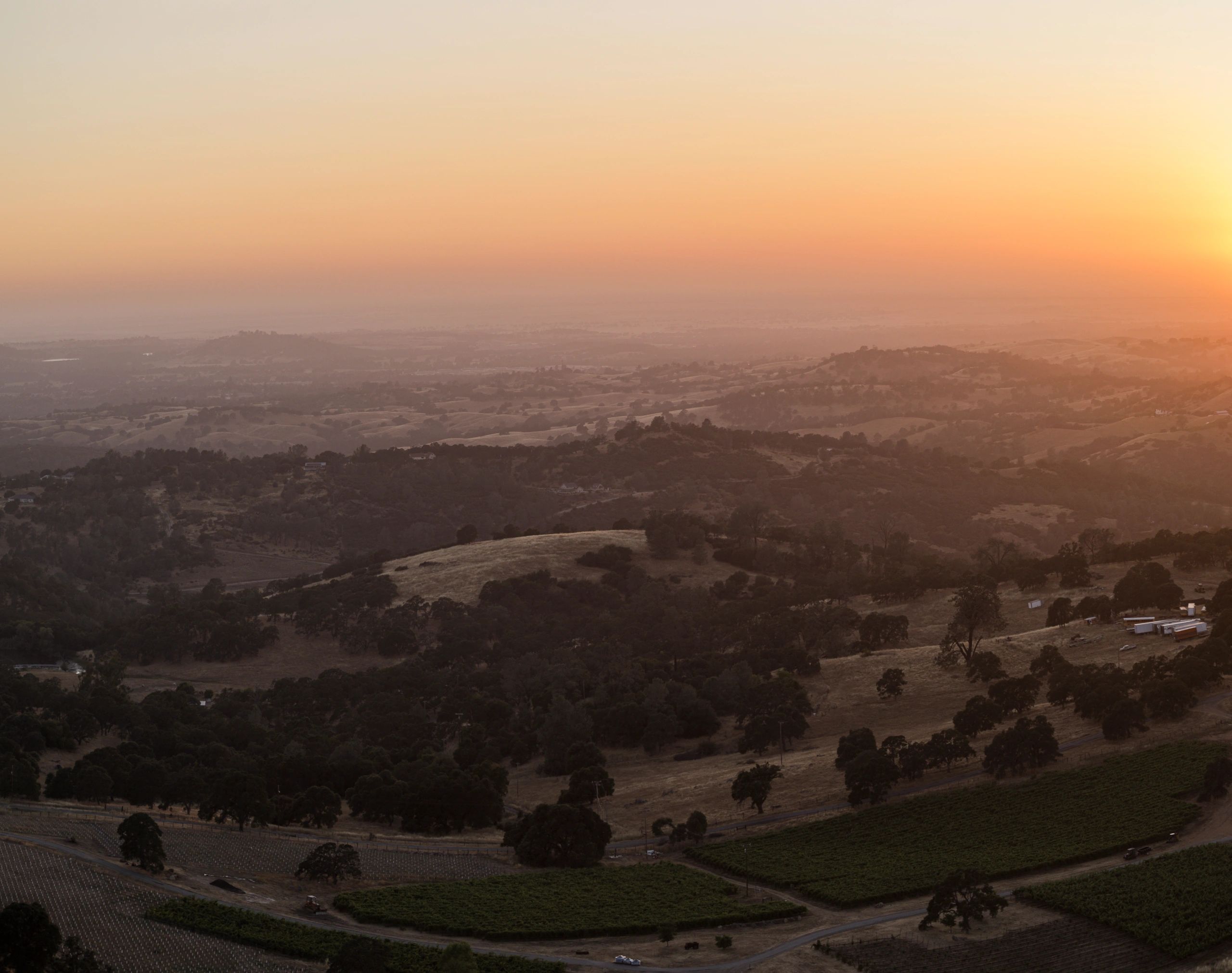O crepúsculo ilumina o vale agrícola. Vista da rodovia com vista para o condado de Amador, fazendas da Califórnia.